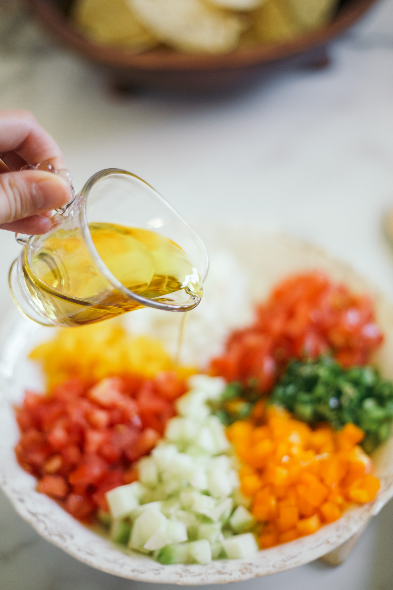 pouring olive oil over vegetables fresh salsa